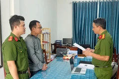 Cơ quan Công an thi hành Lệnh bắt tạm giam đối với Bùi Quang Huy. (Ảnh: TTXVN)