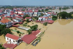 Tỉnh Bắc Ninh đang trải qua đợt ngập lụt nghiêm trọng, nhiều khu dân cư bị nước bao vây, giao thông chia cắt. Biển nước mênh mông phủ kín đồng ruộng và nhà cửa, cuộc sống người dân bị đảo lộn. (Ảnh: Thành Phương/TTXVN)