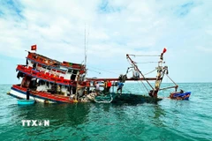 Đồn Biên phòng Hòn Chuối (BĐBP Cà Mau) hỗ trợ cứu vớt tàu cá và ngư dân bị chìm trên biển. (Ảnh: TTXVN phát)