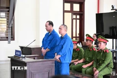 Các bị cáo Đặng Thanh Tuấn và Phạm Văn Tiến nghe Hội đồng xét xử Tòa án nhân dân tỉnh Tây Ninh tuyên án. (Ảnh: TTXVN phát)