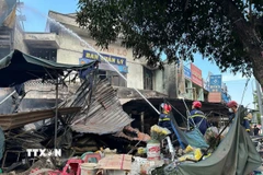 Lực lượng chức năng có mặt kịp thời khống chế ngọn lửa. (Ảnh: Đỗ Trưởng/TTXVN)