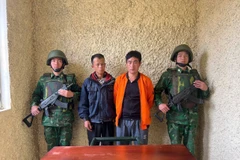 Đối tượng Lầu A Lềnh và Sùng A Say tại cơ quan chức năng. (Ảnh: TTXVN phát)