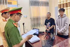 Cơ quan Cảnh sát điều tra tống đạt quyết định khởi tố bị can, lệnh cấm đi khỏi nơi cư trú đối với Võ Duy Khang (áo đen) và Phạm Văn Ý (áo xám)