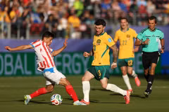 Pha tranh bóng giữa tiền vệ Paraguay Andres Cubas (trái) và tiền vệ Australia Aiden O'Neill. (Ảnh: AFP/TTXVN)