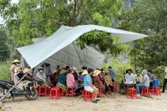 Sáng 12/5/2025, hàng trăm người dân căng bạt, dựng lều…tập trung tại cổng khu vực bãi rác Đông Nam để ngăn các xe chở rác vào tập kết tại bãi. (Ảnh: Khiếu Tư/TTXVN)