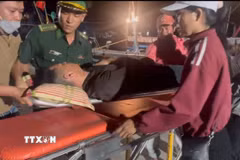 Lực lượng biên phòng đưa ngư dân Võ Kế Luân (27 tuổi) vào bờ để cấp cứu. (Ảnh: TTXVN phát)