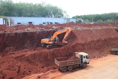 Sau khi báo chí phản ánh, chiều 2/3, một số phương tiện cơ giới đã bắt đầu hạ taluy khu vực nhà dân bị “treo cao.” (Ảnh: Đậu Tất Thành/TTXVN)