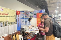 Khách thăm quan gian hàng Việt Nam thảo luận với đại diện doanh nghiệp da giày.