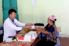 Phát thuốc miễn phí cho nhân dân vùng bị ngập lụt xã Chiềng Khoong, tỉnh Sơn La. (Ảnh: Quang Quyết/TTXVN)