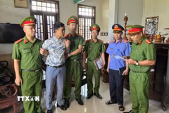 Thi hành lệnh bắt và khám xét nơi ở đối với bị can Mai Hoàng để phục vụ điều tra. (Ảnh: TTXVN phát)