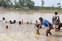 Người dân dùng dụng cụ truyền thống bắt cá tại Lễ hội Phá Bàu. (Ảnh: K GỬIH/TTXVN)