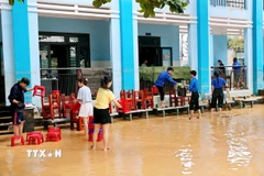 Mặc dù nước chưa rút hết khỏi sân trường nhưng các cô giáo trường Tiểu học Kim Đồng, phường Điện Bàn đã đến trường để dọn dẹp vệ sinh. (Ảnh: Anh Dũng/TXVVN)