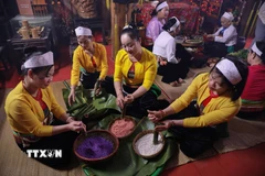 Công đoạn làm bánh chưng, bánh ống, cơm lam... thường là việc mà các phụ nữ Mường phải chuẩn bị. (Ảnh: Trọng Đạt/TTXVN)