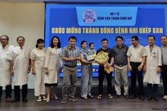 Lãnh đạo, bác sỹ Bệnh viện Trung ương Huế chúc mừng bệnh nhi ghép gan xuất viện. (Ảnh: Mai Trang/TTXVN)
