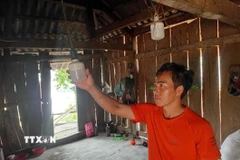 Gia đình anh Thảo A Phừ, bản Sa Lung, xã miền núi Mường Lý chưa được sử dụng điện lưới, phải nấu cơm bằng bếp củi, thắp đèn pin. (Ảnh: Nguyễn Nam/TTXVN)