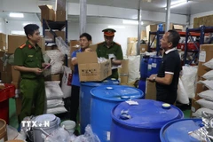 Lực lượng chức năng kiểm tra kho nguyên liệu chế biến các sản phẩm của Gold Care. (Ảnh: TTXVN phát)