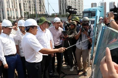 Chủ tịch Ủy ban Nhân dân Thành phố Hồ Chí Minh Nguyễn Văn Được trao đổi tại công trường. (Ảnh: Tiến Lực/TTXVN)