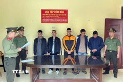 Cơ quan An ninh điều tra Công an tỉnh Tuyên Quang đọc Quyết định khởi tố các đối tượng. (Ảnh: TTXVN phát)