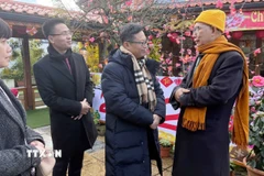 Đại sứ Việt Nam tại Pháp Trịnh Đức Hải (ngoài cùng bên phải) gửi lời chúc mừng năm mới tới Hòa thượng Thích Thịnh Quang, Trụ trì chùa Khuông Việt. (Ảnh: Hữu Chiến/TTXVN)