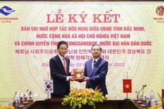 Chủ tịch Ủy ban Nhân dân tỉnh Bắc Ninh Phạm Hoàng Sơn (bên phải) tặng biểu tượng trống Đồng cho ngài Lee Cheol Woo, Tỉnh trưởng tỉnh Gyeongsangbuk (Hàn Quốc). (Ảnh: Thanh Thương/TTXVN)