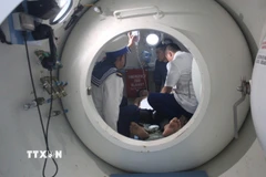 Các bác sỹ tiến hành cấp cứu cho ngư dân bị giảm áp. (Ảnh: TTXVN phát)