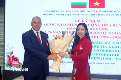 Bà Hà Thanh, Chủ tịch Liên hiệp các tổ chức hữu nghị Thành phố Hồ Chí Minh, tặng hoa chúc mừng ông Oleg Marino, Trưởng Văn phòng Thương mại và Kinh tế Bulgaria tại Thành phố Hồ Chí Minh. (Ảnh: Xuân Khu/TTXVN)