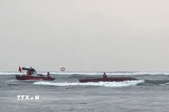 Đồn Biên phòng Nhật Lệ khẩn trương triển khai lực lượng, phương tiện tiếp cận tàu cá và cứu, đưa ngư dân Nguyễn Tiến Hoàng vào bờ. (Ảnh: TTXVN phát)