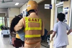 Hình ảnh chiến sỹ CSGT bế người phụ nữ tại hành lang bệnh viện lan truyền mạnh mẽ, nhận được nhiều lời khen ngợi từ cộng đồng. (Ảnh cắt từ clip)