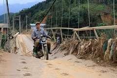 Tuy ý thức rõ ràng sự nguy hiểm, nhưng vì đây là cây cầu độc đạo nên người dân vẫn liều mình hàng ngày đi qua cầu treo này. (Ảnh: Anh Thùy/TTXVN)