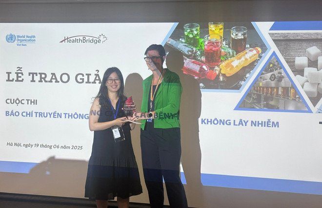Tiến sỹ Angela Pratt - Trưởng Đại diện WHO tại Việt Nam trao giải Nhất cho Nhà báo Vũ Thị Nam Phương (Báo Dân trí). (Ảnh: PV/Vietnam+) giai-thuong.jpg