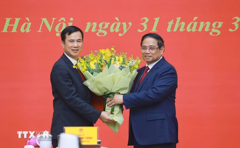 Thủ tướng Phạm Minh Chính tặng hoa chúc mừng ông Bùi Thế Duy giữ chức Giám đốc Đại học Quốc gia Hà Nội. (Ảnh: Dương Giang/TTXVN)