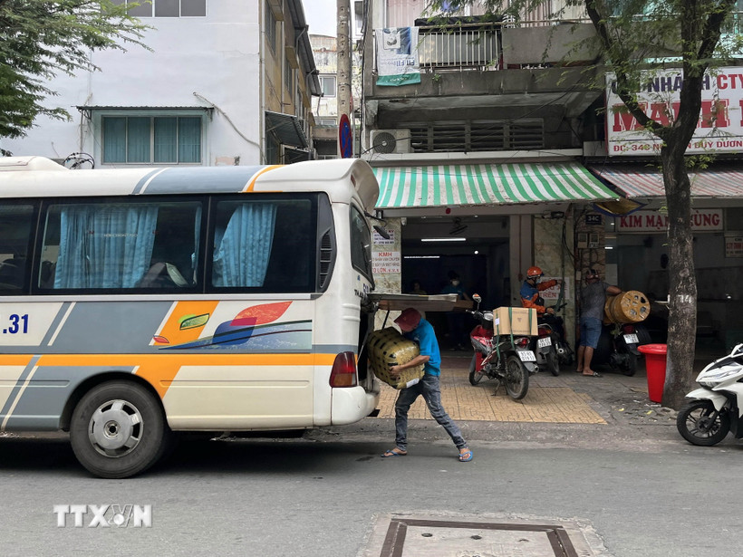 Giao nhận hàng hóa trước vị trí số 34C Nguyễn Duy Dương, nơi được liệt kê là “xe dù, bến cóc.” (Ảnh: Tiến Lực – TTXVN)