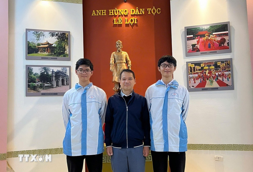 Thầy giáo Bùi Văn Bình, giáo viên môn Toán Trường THPT chuyên Lam Sơn chụp ảnh cùng Phúc Khánh (bên trái) và Vĩnh Kỳ. (Ảnh: TTXVN phát)