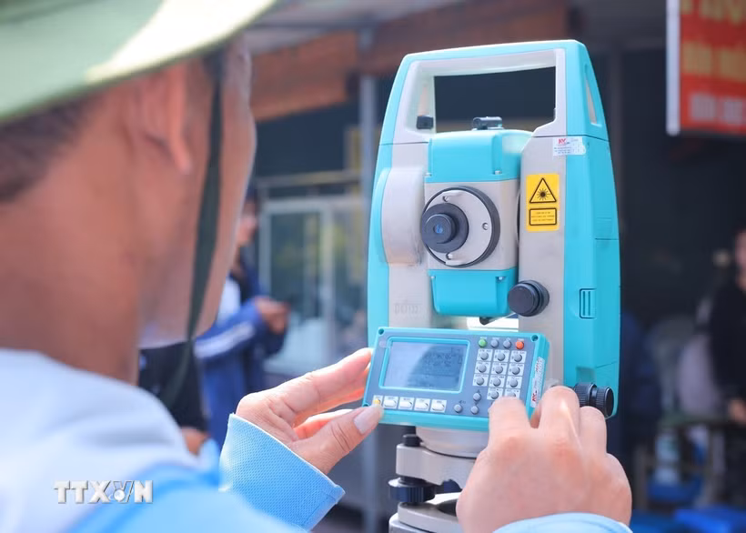 Nhân viên đo đạc sử dụng máy toàn đạc để xác định mốc, thu thập số liệu hiện trạng. (Ảnh: Hoàng Hiếu/TTXVN)