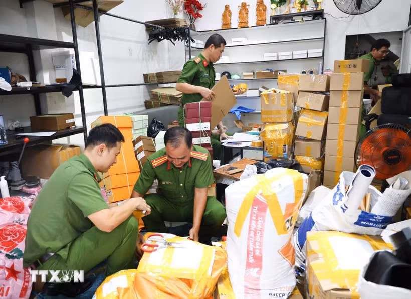 Công an thành phố Cần Thơ phối hợp Chi Cục quản lý thị trường thành phố Cần Thơ kiểm đếm, niêm phong số lượng lớn dép “giả” thương hiệu nổi tiếng tại cửa hàng T.D Luxury. (Ảnh: TTXVN phát)