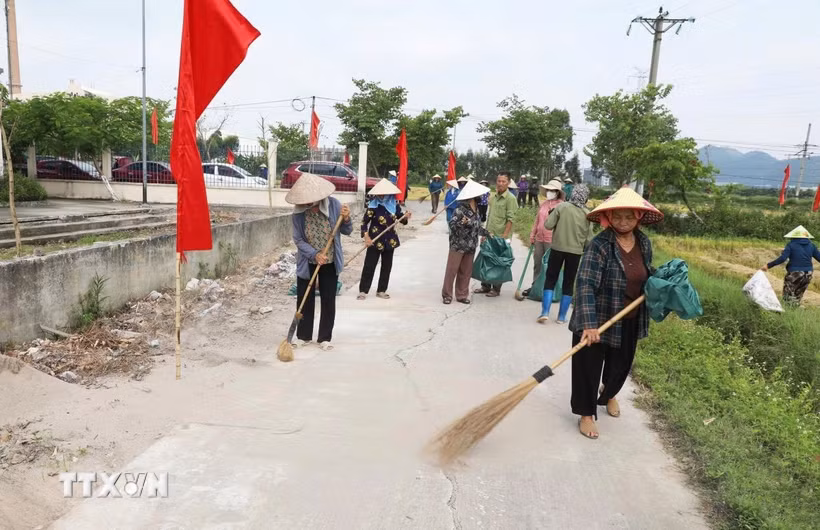 Cán bộ, hội viên Hội nông dân phường Yên Dũng, Bắc Ninh, tham gia quét dọn, thu gom rác thải, bảo vệ môi trường. (Ảnh: Việt Hùng/TTXVN)