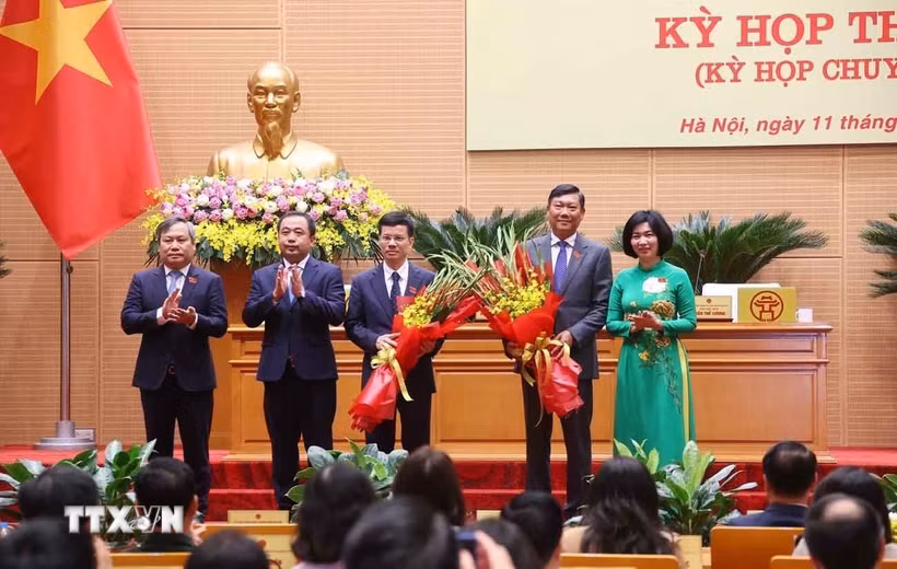 Lãnh đạo thành phố Hà Nội tặng hoa, chúc mừng tân Phó Chủ tịch Ủy ban Nhân dân thành phố Hà Nội Đỗ Anh Tuấn và Bùi Duy Cường. (Ảnh: Văn Điệp/TTXVN)