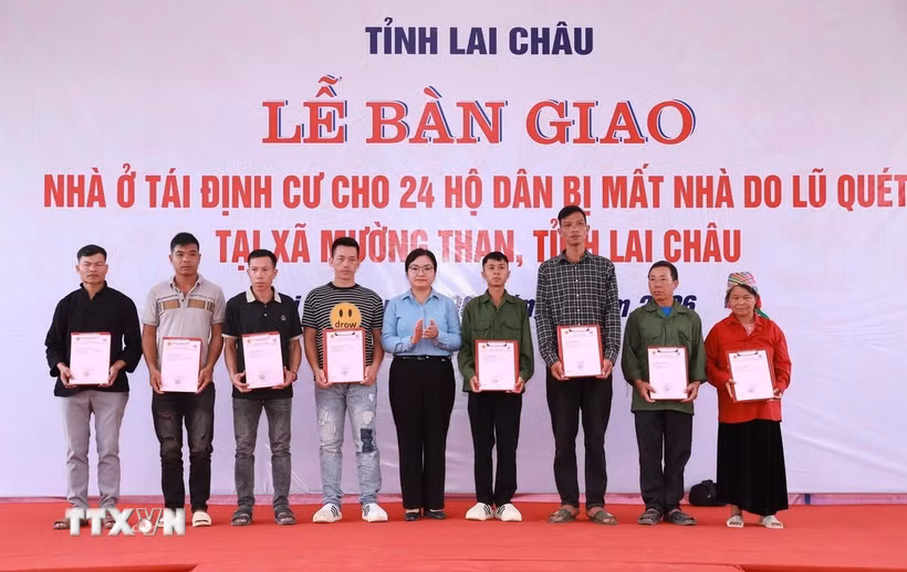 Chủ tịch xã Mường Than, tỉnh Lai Châu, Nguyễn Thị Thu Thủy trao Giấy chứng nhận quyền sử dụng đất và tài sản trên đất cho các hộ dân. (Ảnh: Quý Trung/TTXVN)