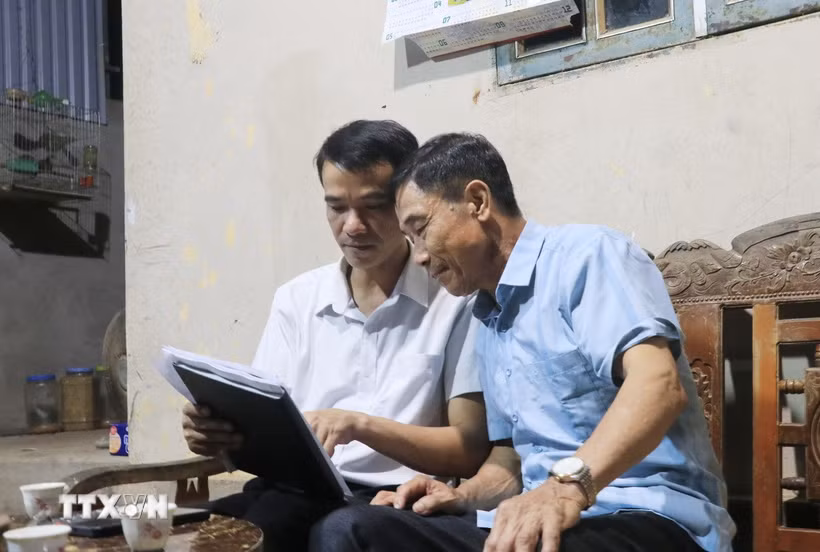 Cán bộ xã đến từng hộ dân tuyên truyền và lấy ý kiến nhân dân về chủ trương sáp nhập thôn. (Ảnh minh họa: Anh Thùy/TTXVN)