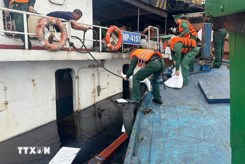 Trong quá trình bốc dỡ hàng hóa, do sơ suất khi vận hành cần cẩu, dây cáp bị tuột khiến cọc bê tông rơi xuống làm thủng đáy tàu, nước tràn vào khoang gây ngập tàu. (Ảnh: TTXVN phát)