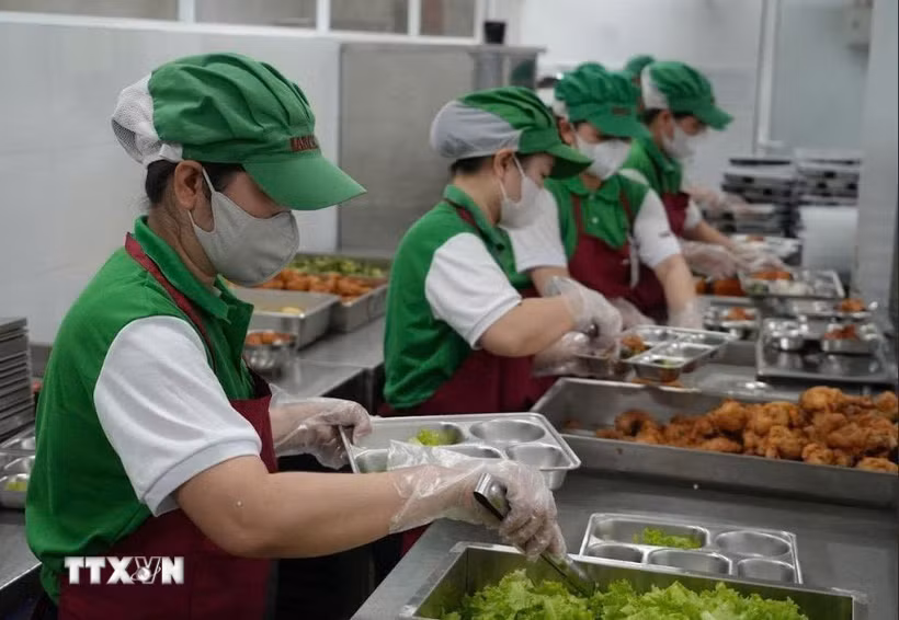 Nhân viên bếp ăn bán trú tại một trường Tiểu học trên địa bàn phường Nha Trang đảm bảo các khâu an toàn trong việc chia, phát thức ăn vào khay trước giờ dùng bữa của học sinh. (Ảnh: Phan Sáu/TTXVN)