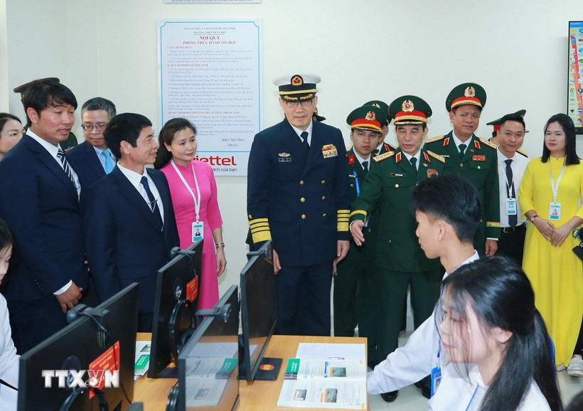 Bộ trưởng Quốc phòng Phan Văn Giang và Bộ trưởng Quốc phòng Trung Quốc Đổng Quân tham quan các phòng học vi tính của trường THPT Trần Phú. (Ảnh: Trọng Đức/TTXVN)