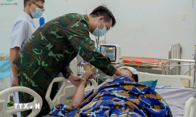 Các bác sỹ tích cực cấp cứu cho người bệnh tại Trạm xá đảo Sinh Tồn. (Ảnh: TTXVN phát)