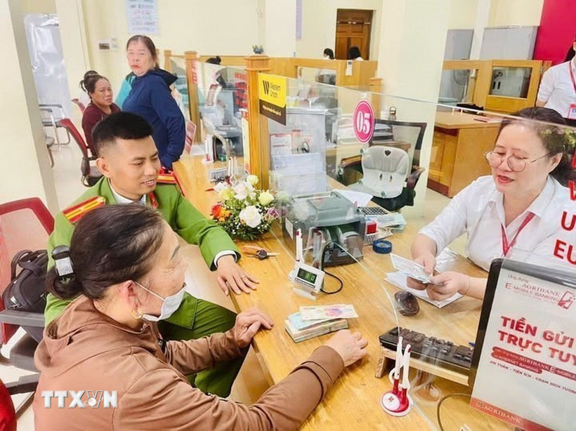 Công an phường Sầm Sơn và Ngân hàng Agribank kịp thời ngăn chặn người dân chuyển tiền cho các đối tượng lừa đảo. (Ảnh: TTXVN phát)