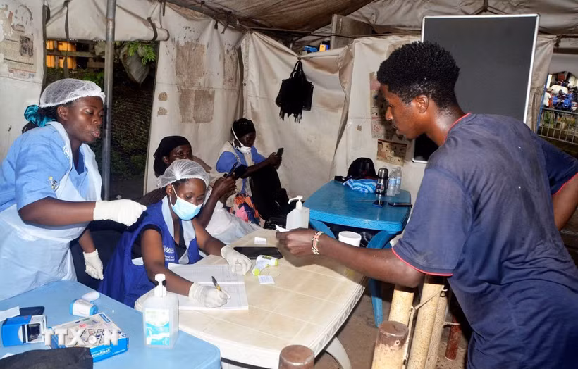 Nhân viên y tế lấy thông tin của hành khách nhập cảnh tại điểm kiểm soát biên giới Mpondwe, Uganda. (Ảnh: THX/TTXVN)