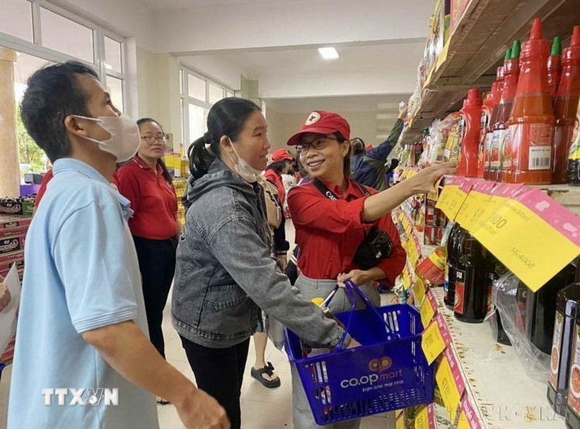 Nhân viên Hội Chữ thập Đỏ Đà Nẵng hỗ trợ người dân lựa chọn các nhu yếu phẩm tại Chương trình Tết Nhân ái. (Ảnh: Trần Lê Lâm/TTXVN)