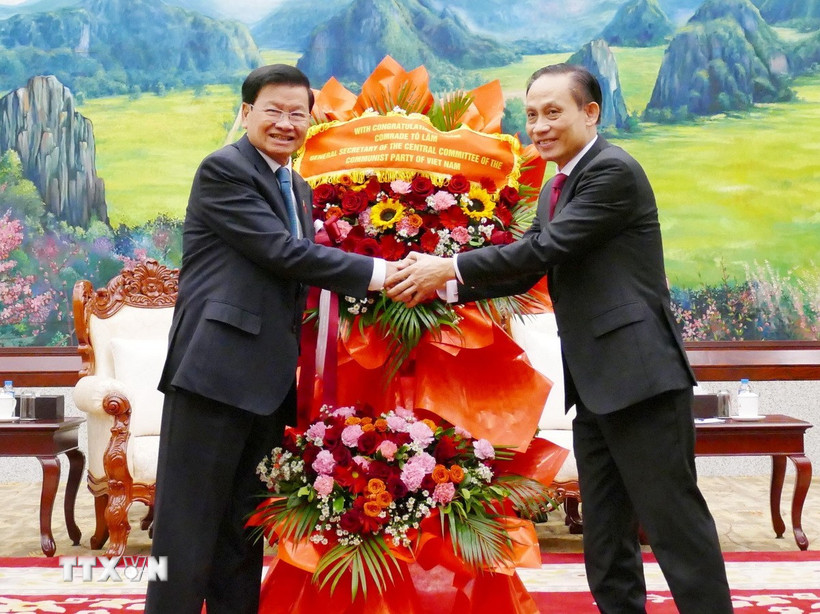 Đặc phái viên của Tổng Bí thư Tô Lâm, ông Lê Hoài Trung chúc mừng Tổng Bí thư Ban Chấp hành Trung ương Đảng Nhân dân cách mạng Lào khóa XII, Chủ tịch nước Lào Thongloun Sisoulith. (Ảnh: Xuân Tú/TTXVN)
