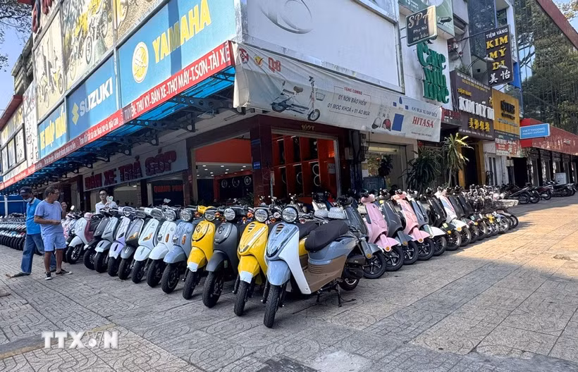 Khách hàng lựa chọn xe máy điện trên đường An Dương Vương nhằm thích ứng linh hoạt trước biến động của thị trường nhiên liệu. (Ảnh: Thanh Vũ/TTXVN)