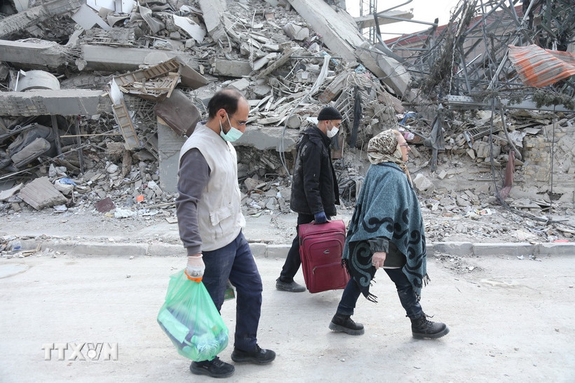 Người dân đi qua đống đổ nát của những tòa nhà bị phá hủy tại Tehran, Iran. (Ảnh: THX/TTXVN)