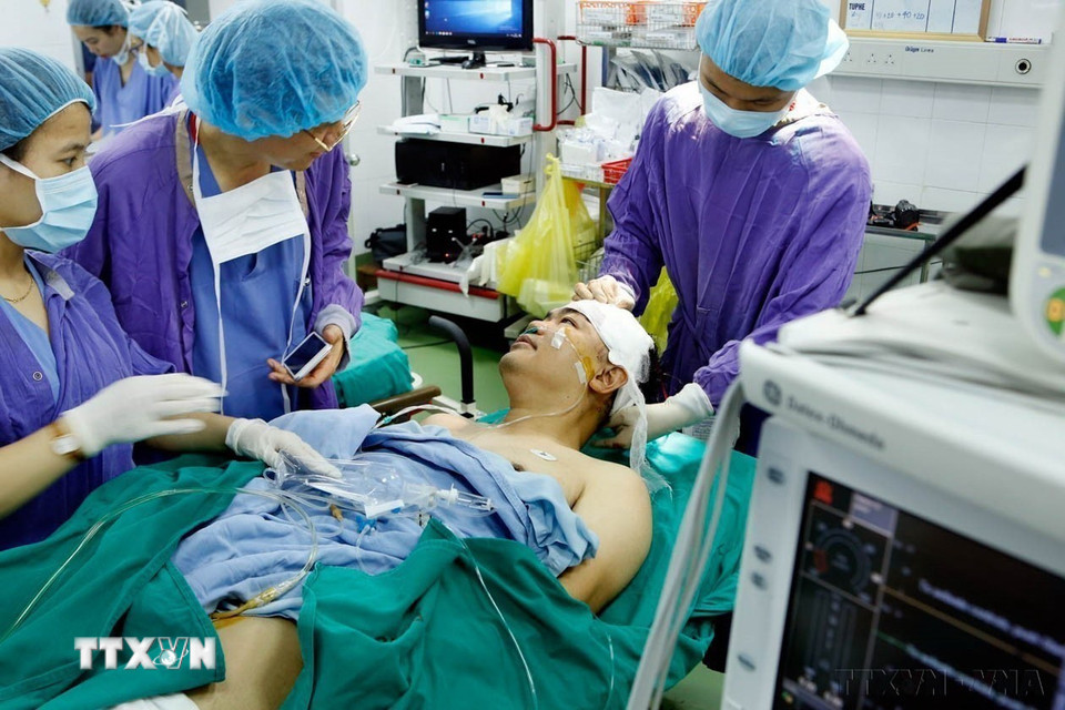 Phó Giáo sư-Tiến sỹ Đồng Văn Hệ, Phó Giám đốc bệnh viện Hữu nghị Việt Đức nói chuyện bình thường với bệnh nhân ngay trên bàn mổ, sau khi thực hiện ca phẫu thuật u não bằng phương pháp “Mổ thức tỉnh” lần đầu tiên tại Việt Nam năm 2019. (Ảnh: Dương Ngọc/TTXVN)